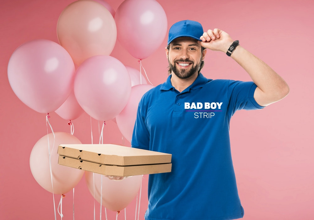 Pizza delivery guy-themed Bad Boy holding a pizza box in one hand and smiling at the viewer.