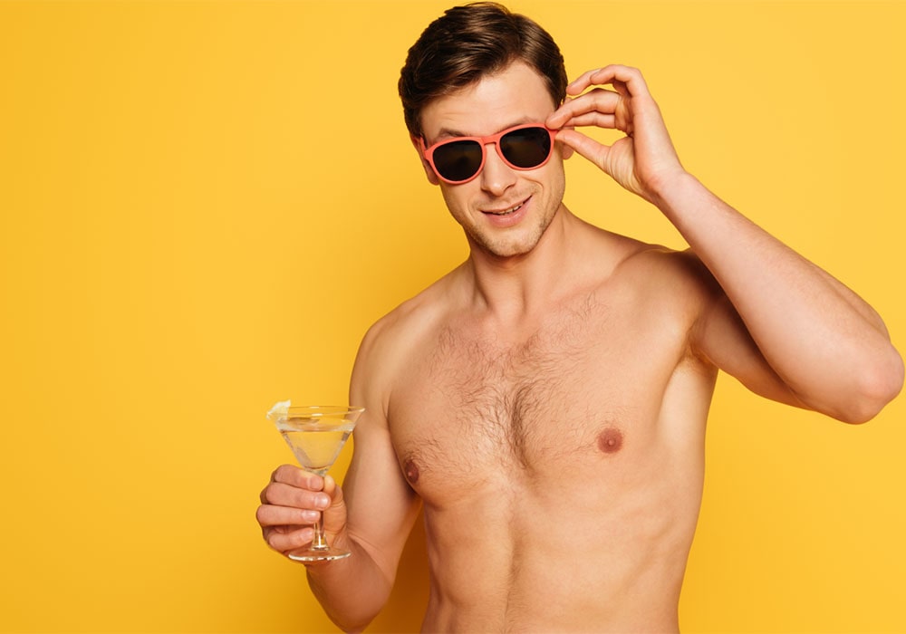 Shirtless men wearing sunglasses and holding a glass of martini in front of a yellow background.