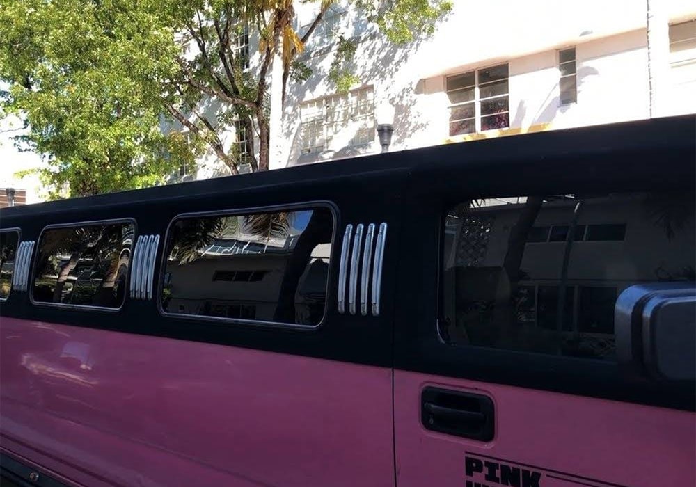 Pink Hummer parked in front of a building